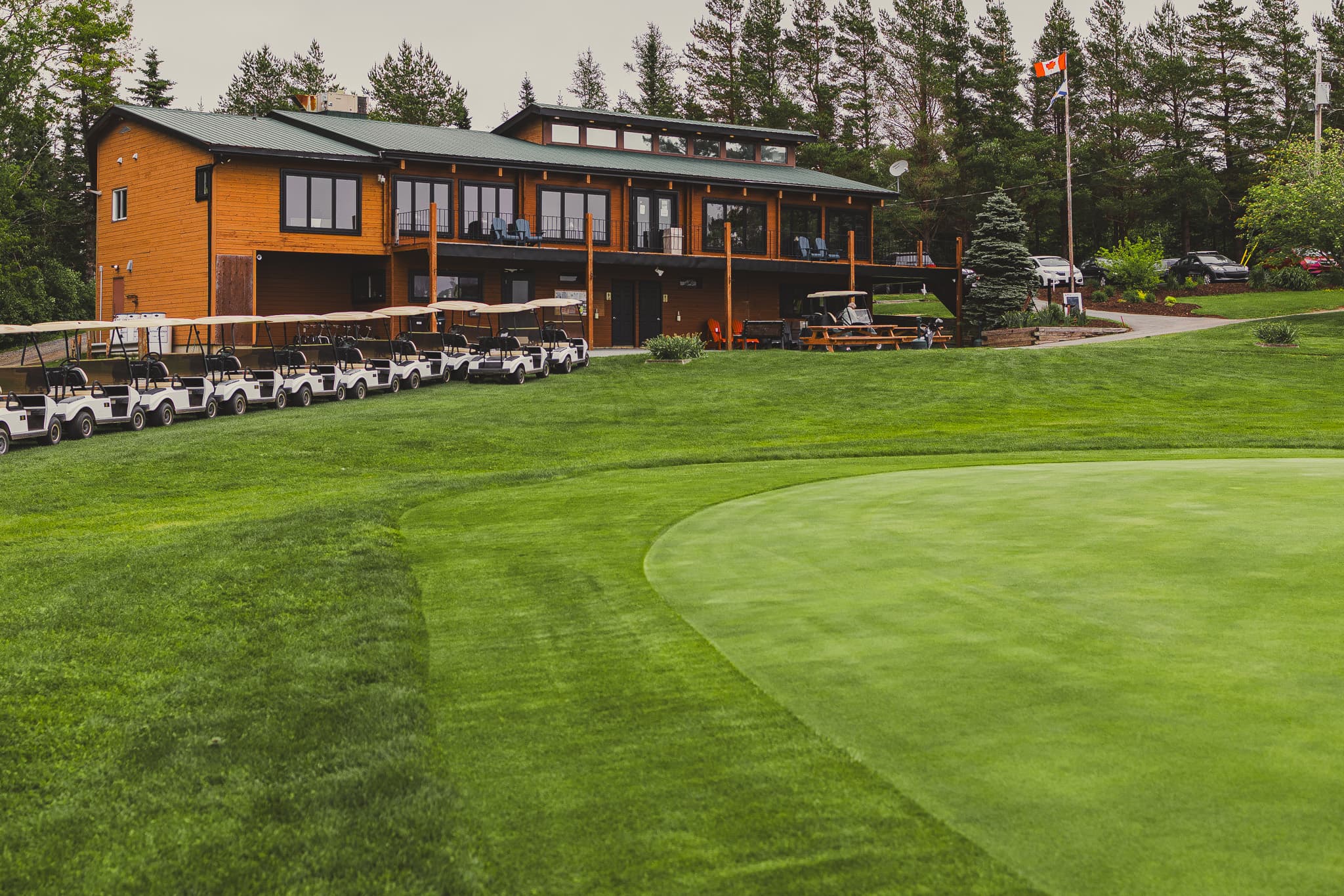 Clubhouse 24/7 exterior with golf carts beside the putting green